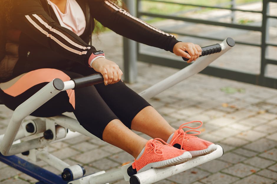 A woman in sportswear works out on outdoor fitness equipment, focusing on health and recreation